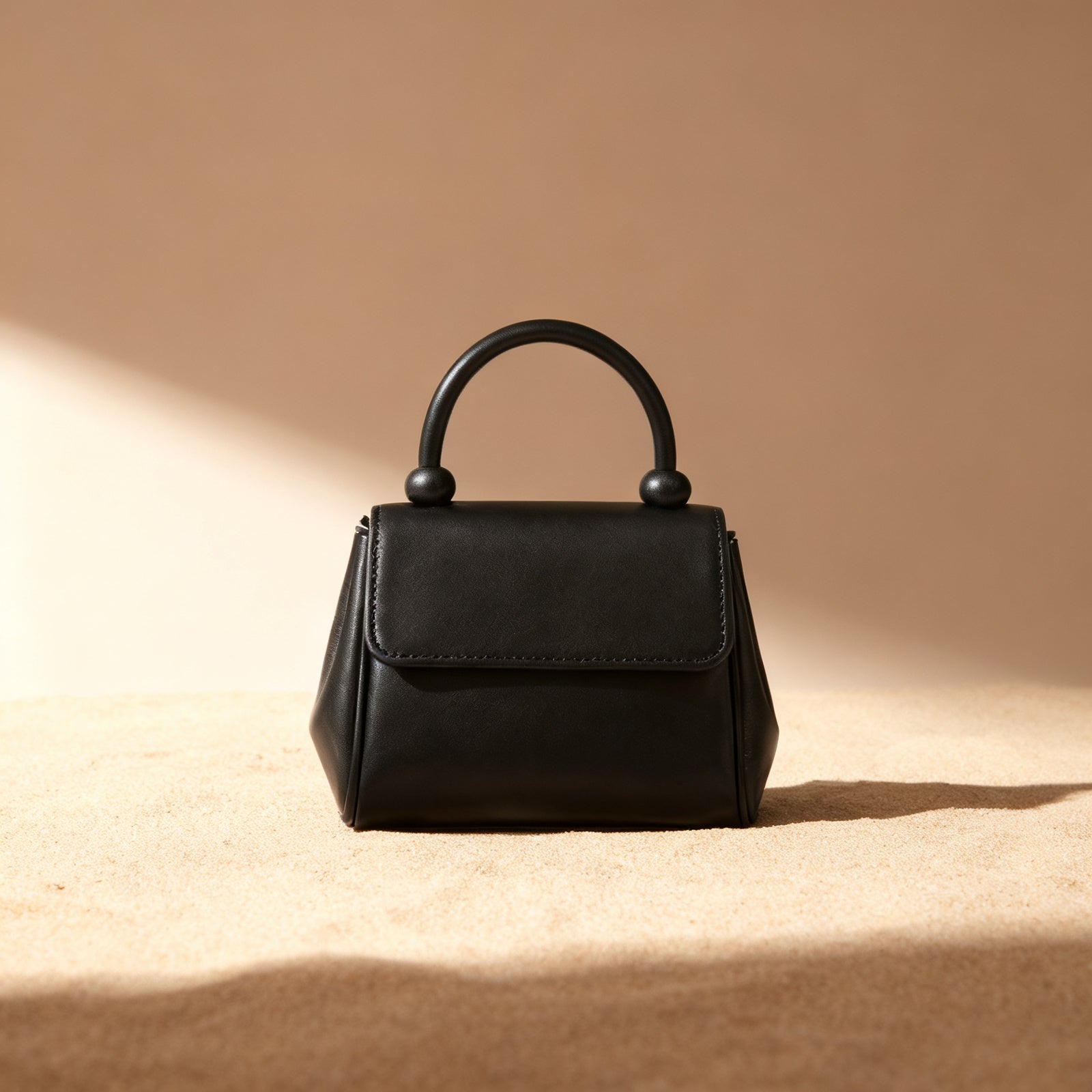 The Top-Handle Bag in black exterior, front view